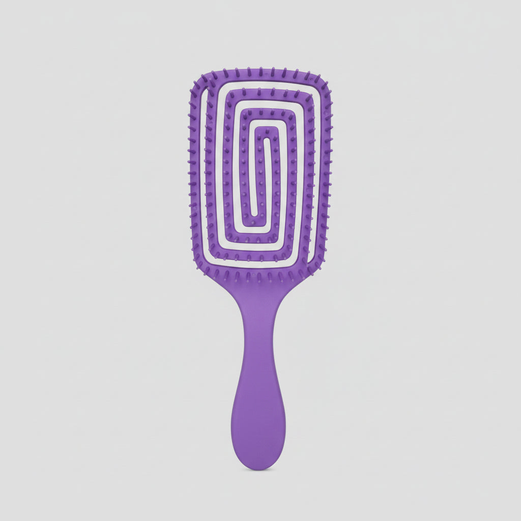 A purple paddle hairbrush with a unique spiral groove design on the bristle head, resting on a white sheet of paper over a wooden surface.